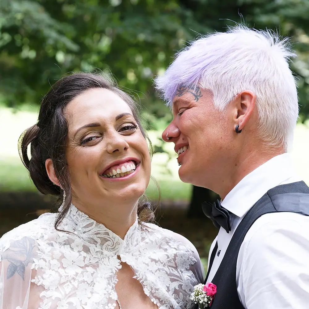 Mariage entre deux femmes à Nœux-les-Mines | Photographe Pas-de-Calais Photographie joyeuse de Jessica et Marina, deux jeunes mariées se souriant tendrement pendant leur mariage à Nœux-les-Mines. Un moment d'amour sincère capturé par un photographe de mariage près de Lens.