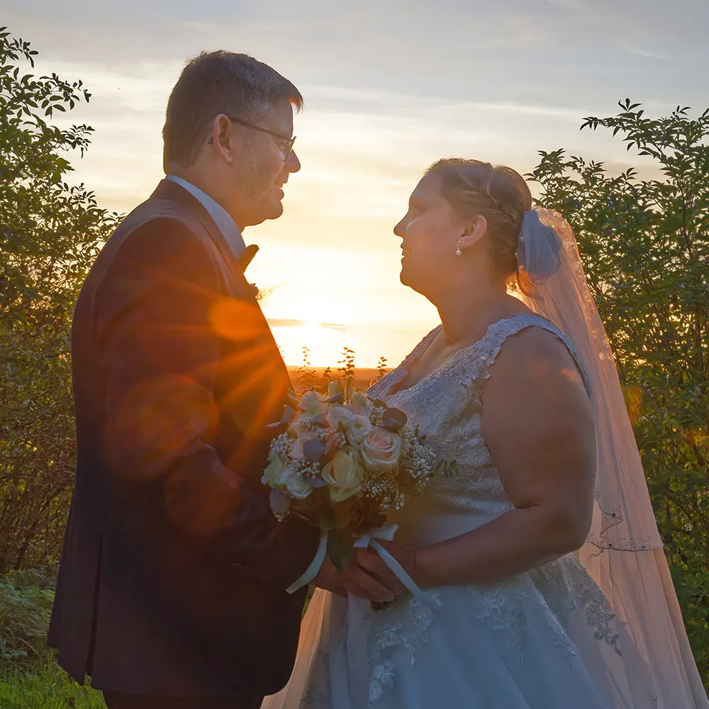 Photo de couple de mariés au coucher du soleil | Photographe Arras Photographie romantique du couple de mariés se regardant avec tendresse au coucher du soleil. Un moment magique immortalisé par un photographe de mariage près d'Arras et de Lens.