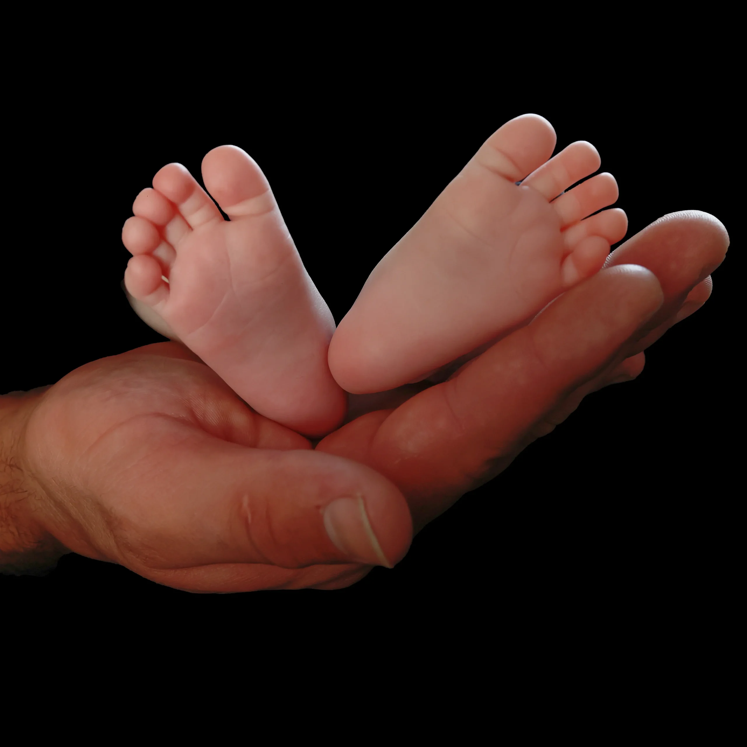 Les pieds d'un bébé est placé en éventail sur la main de papa? le fond est noir, on ne voit pas le bébé.