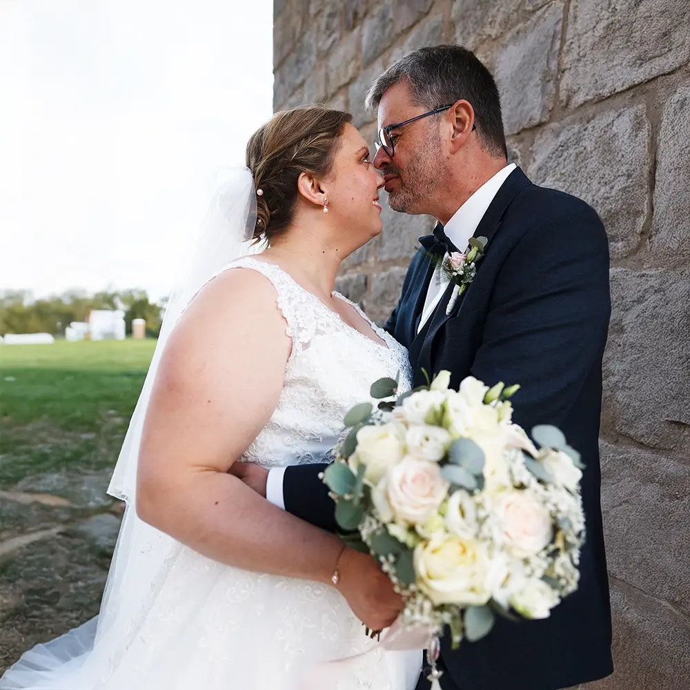 Portrait de couple de mariés | Photographe Mariage Arras Portrait romantique du couple de mariés, sur fond de mur en pierre, un instant de tendresse au soleil couchant. Photographe de mariage à Dainville, près d'Arras et Lens.