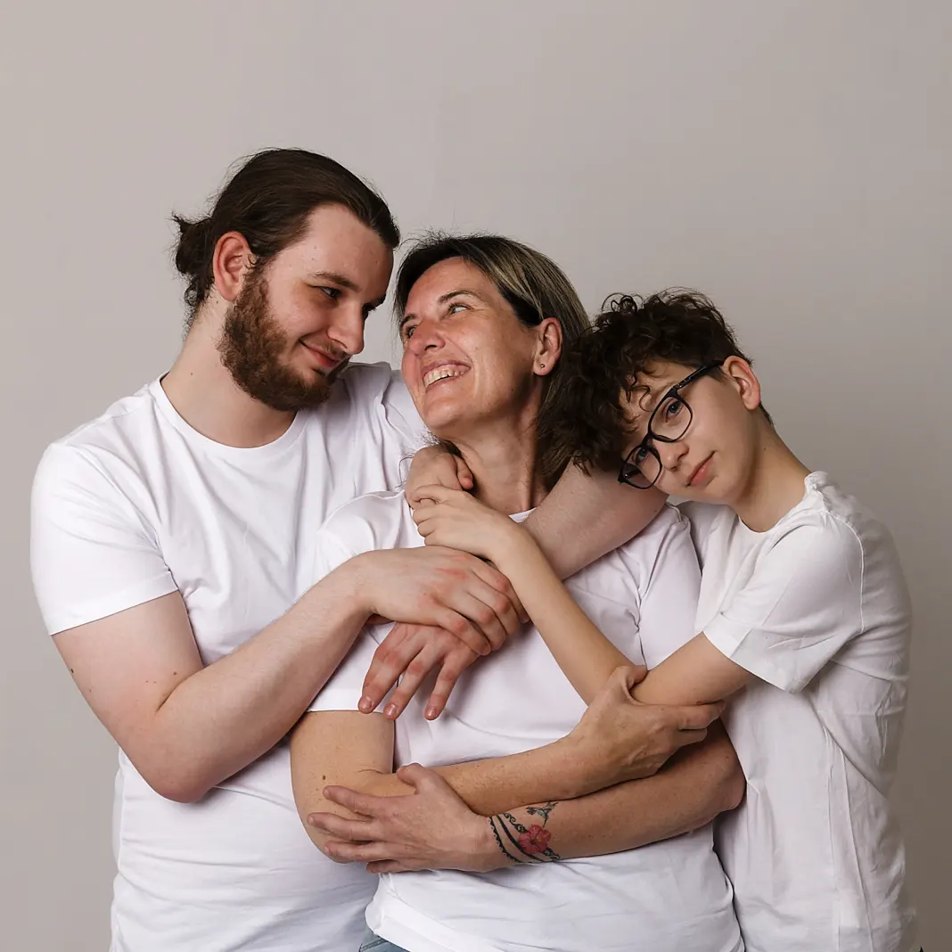 Photo de famille intime, montrant une mère et ses deux fils s'enlaçant, partageant un moment de complicité et de bonheur, capturé par un photographe à Sainte-Catherine.