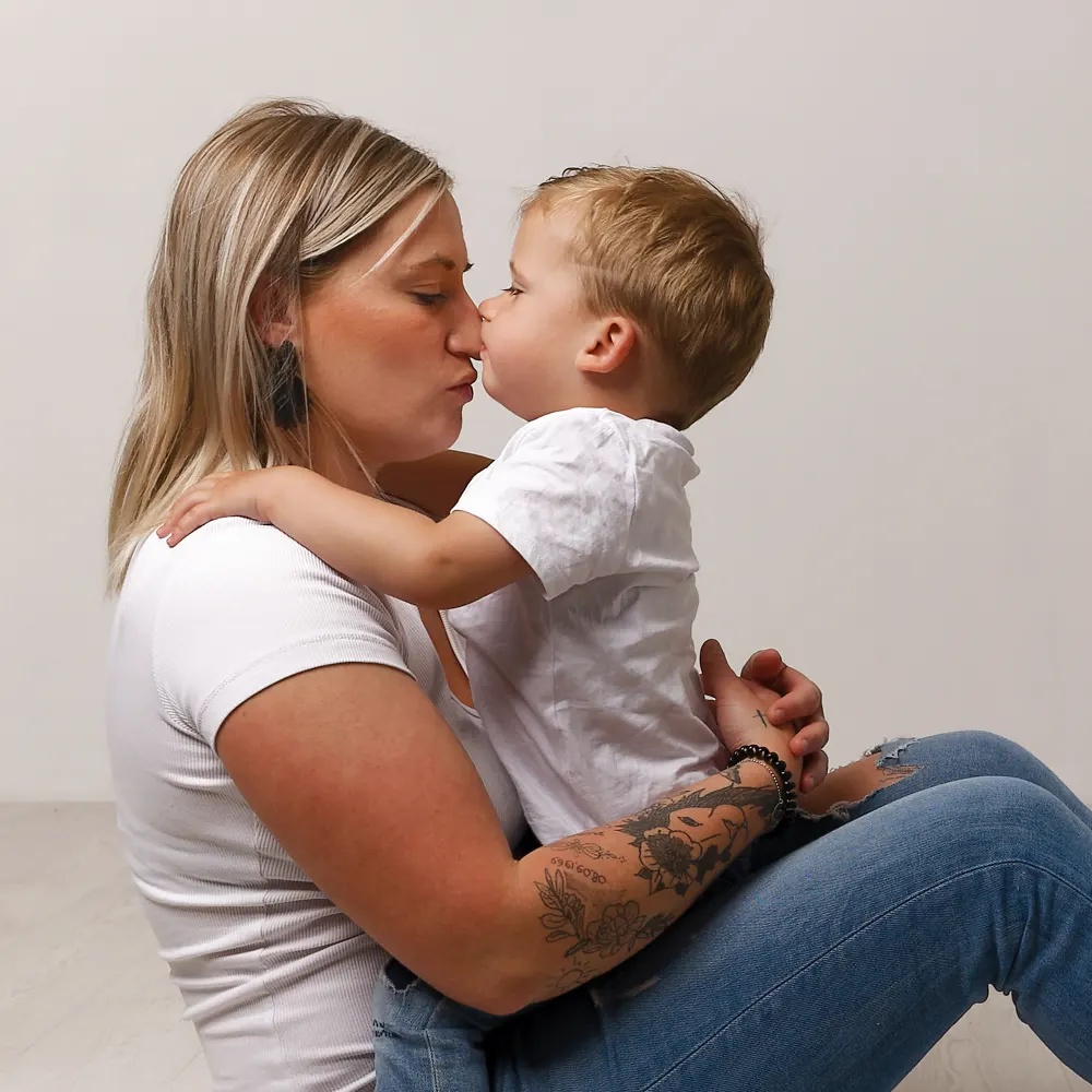 Portrait en studio d'une mère et de son jeune fils face à face, partageant un moment de tendresse et de proximité, capturé par un photographe à Sainte-Catherine.