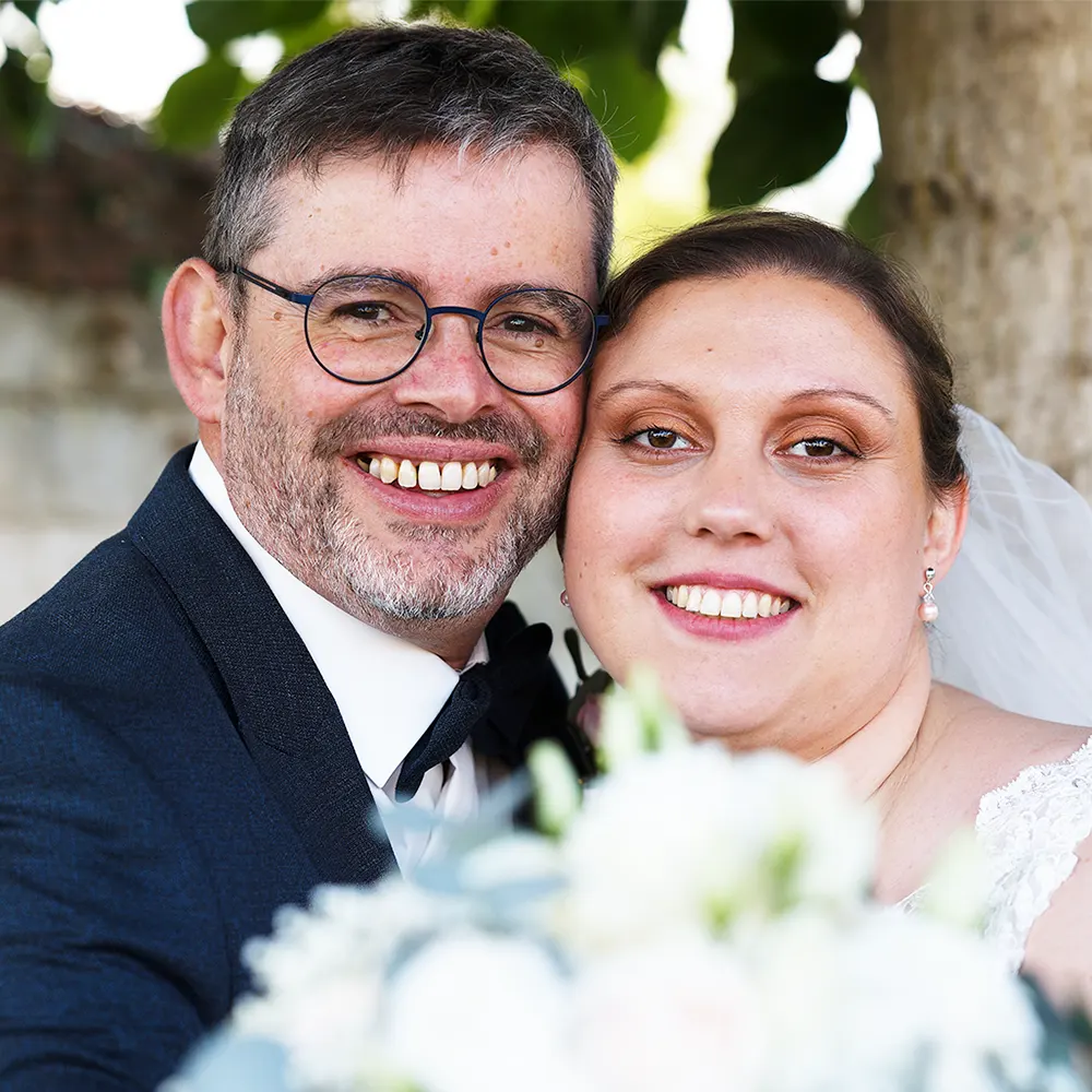 Portraits de mariés à Dainville Photographe de mariage à Arras : portrait de couple de mariés, souriant devant l'objectif. Reportage photo naturel et spontané dans la région de Sainte-Catherine.
