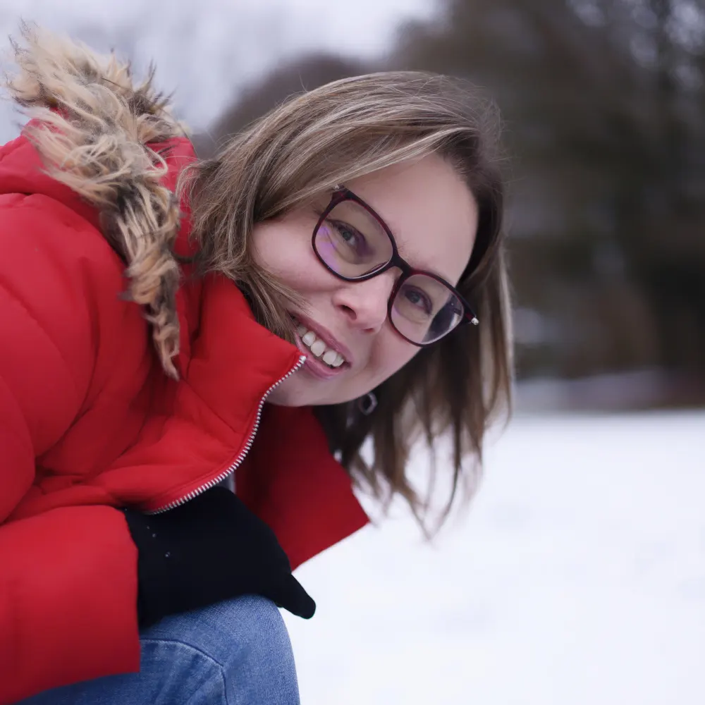 Gros plan sur une femme souriant dans la neige, portrait d'hiver en extérieur à Sainte-Catherine.