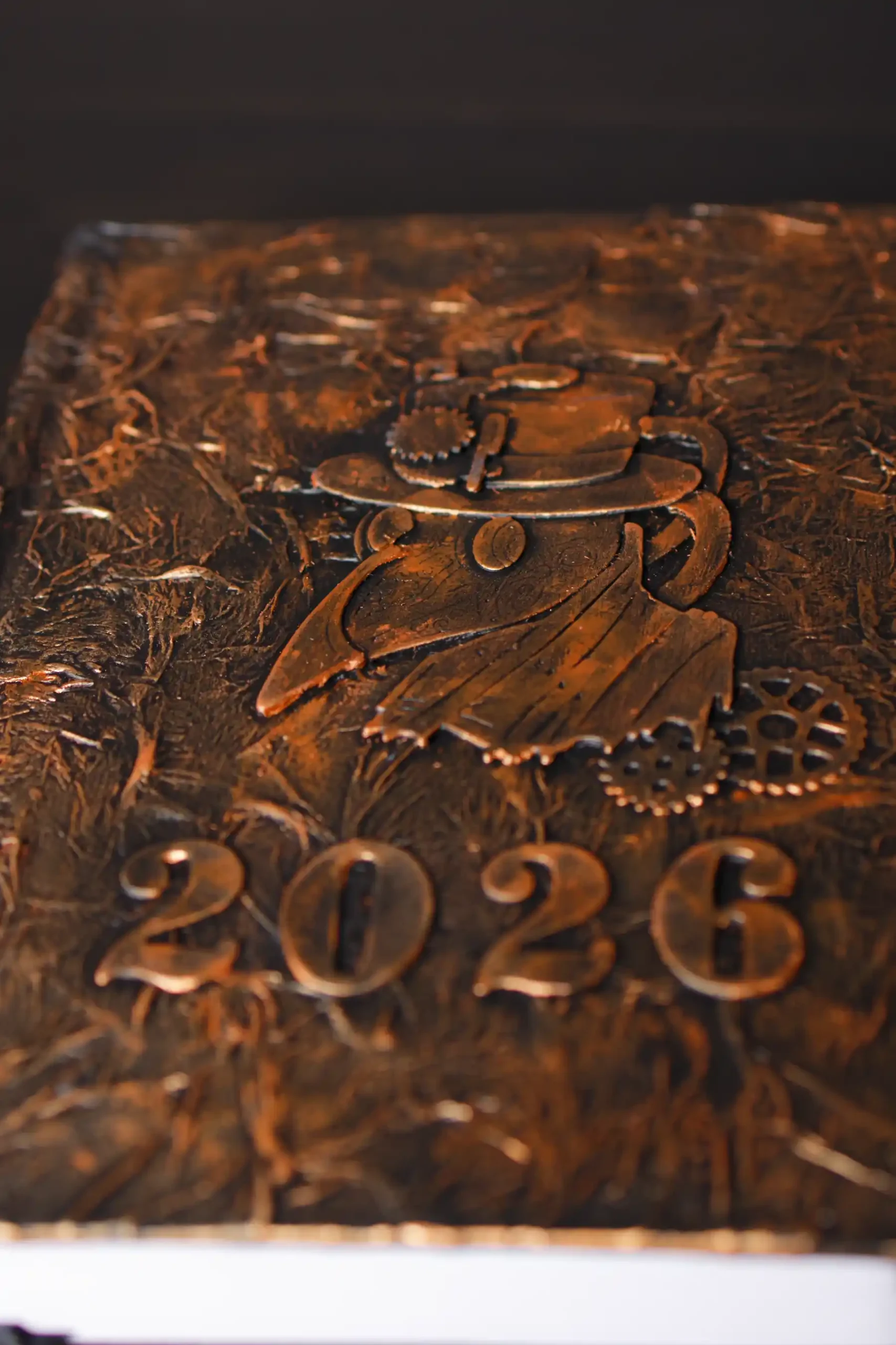 Agenda 2026 décoré dans un style steampunk. La couleur est bronze. Un corbeau est représenté habillé en nsteampunk.