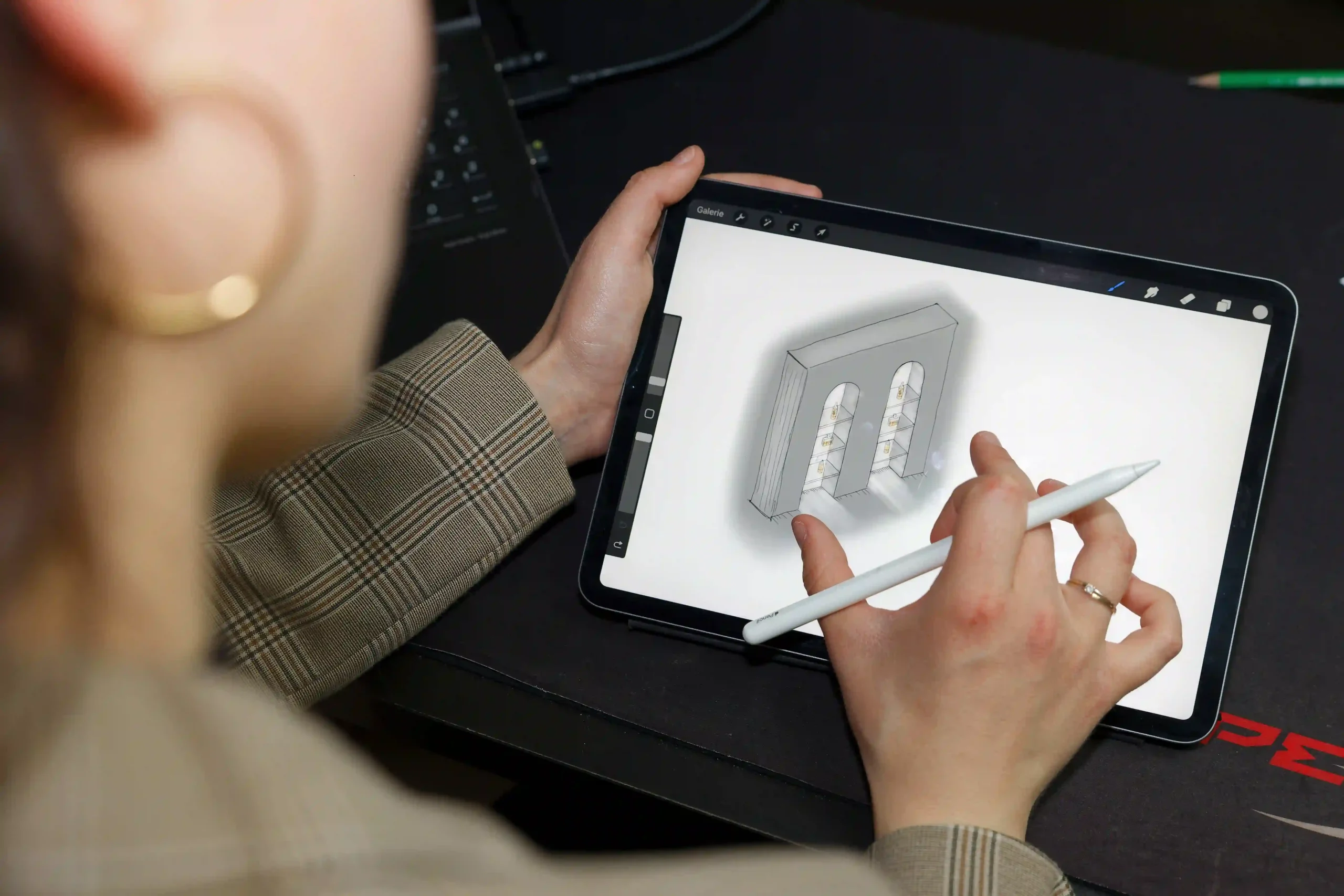Une architecte d'intérieur utilise une tablette et un stylet pour créer un plan de conception 3D d'un espace intérieur