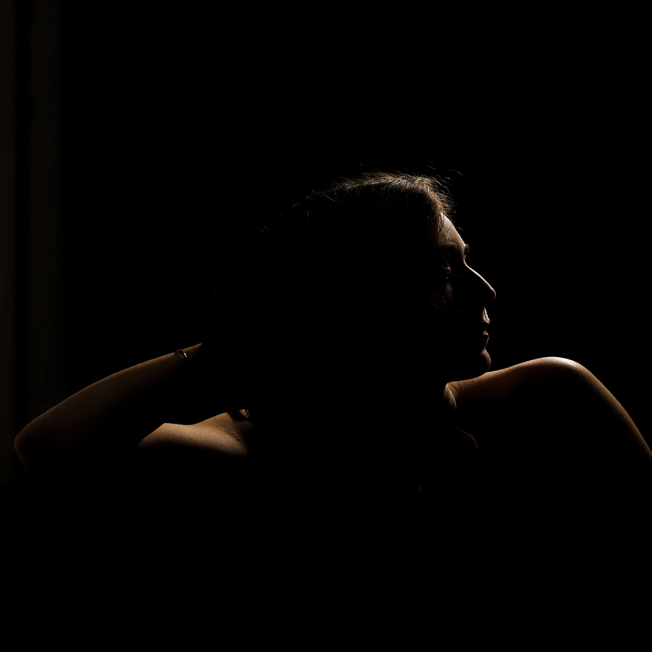 Portrait boudoir artistique en clair obscur d'une femme. Mise en scène créative par votre photographe boudoir à Arras.