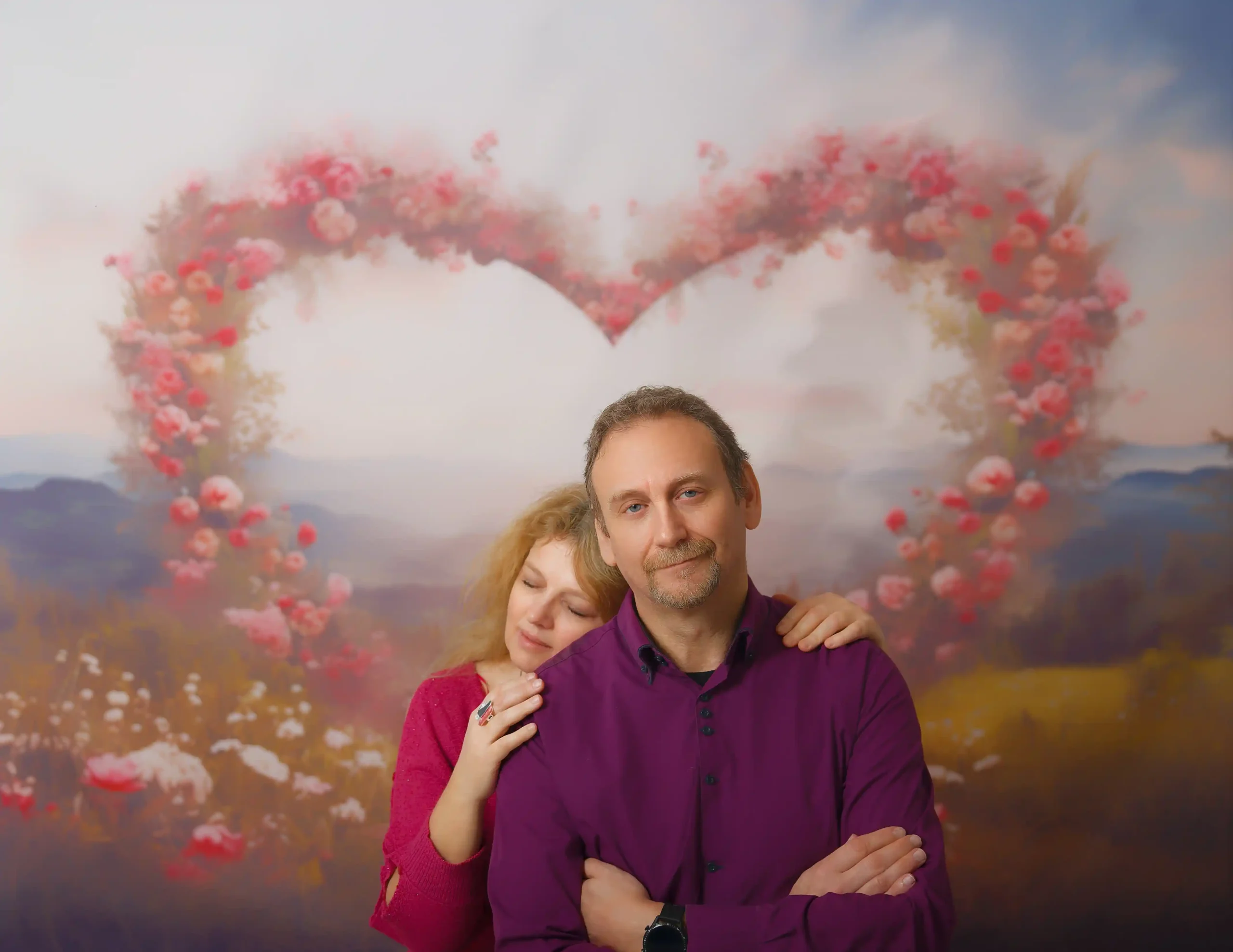 Portrait d'un couple devant une toile de fond. Ce fond de studio représente des fleurs en forme d'un cœur.