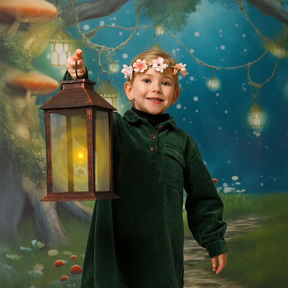 Portrait féerique d'une petite fille en studio, souriant avec une couronne de fleurs et tenant une lanterne allumée, sur un fond de forêt enchantée.