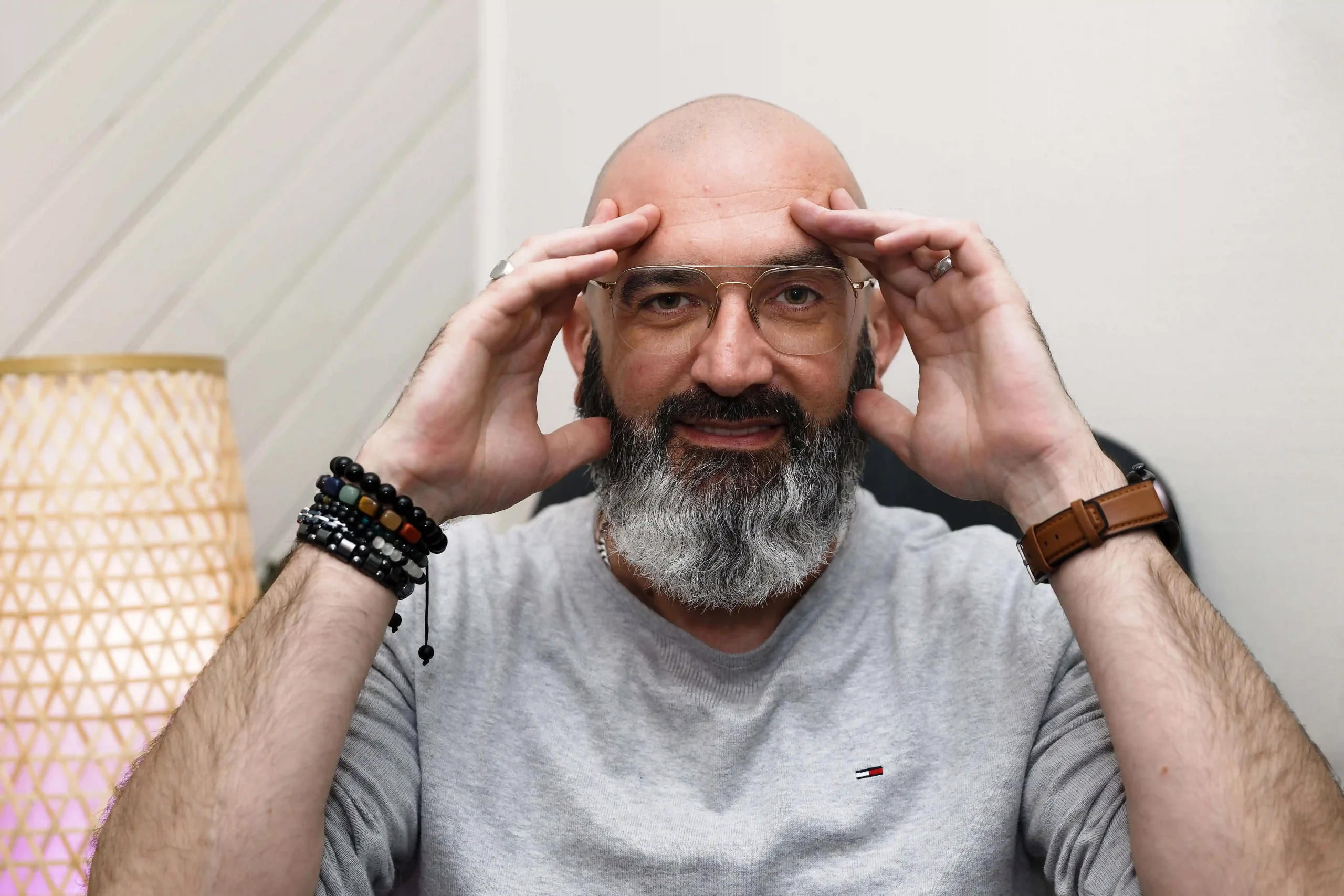 Un hypnotiseur barbu, en pleine concentration, se tenant la tête, symbolisant la réflexion et le travail sur l'esprit.